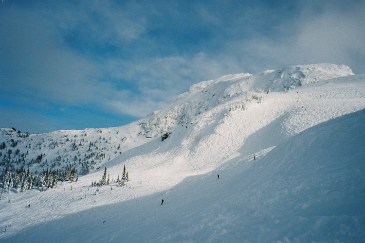 Skiers skiing down mountain in a row