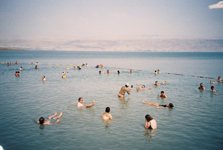 a group of people swimming in the dead sea